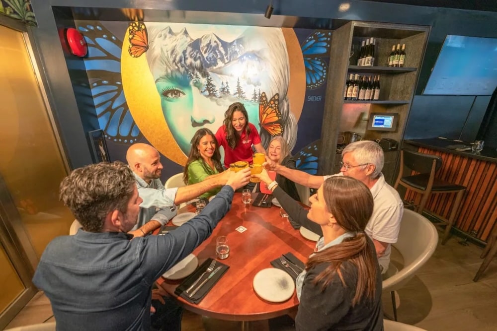 a Vancouver Foodie Tours guide watching as her group of guests raises their drinks to a common cheer