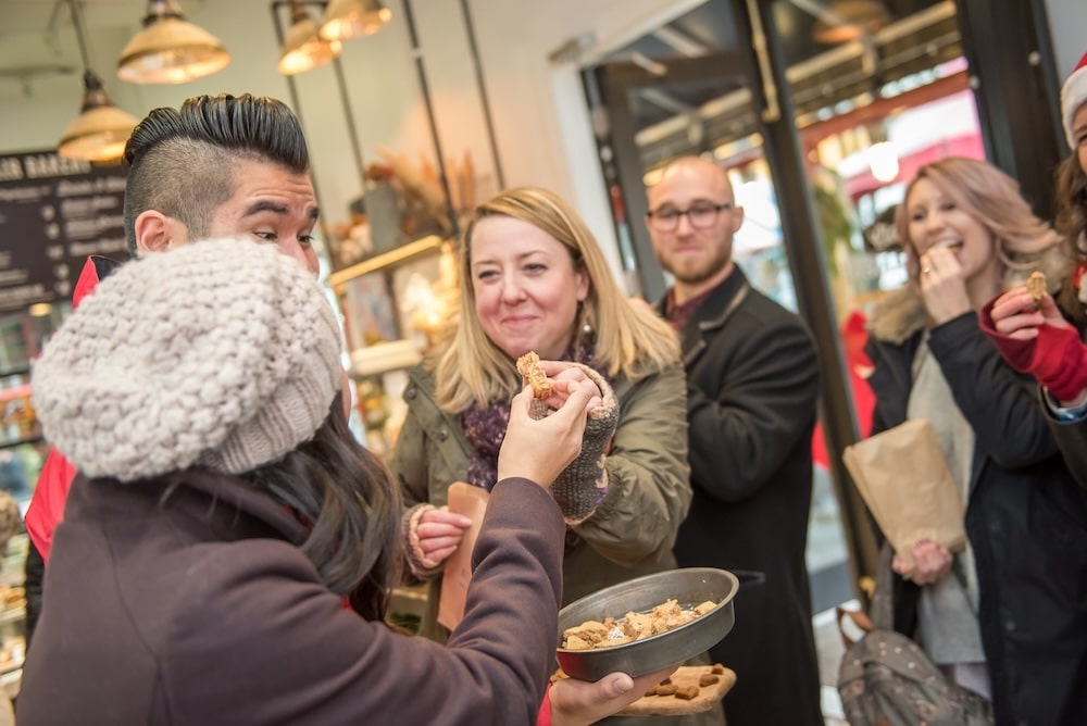 A Vancouver Foodie Tours guide sharing bits of local cuisine with his guests on a food tour