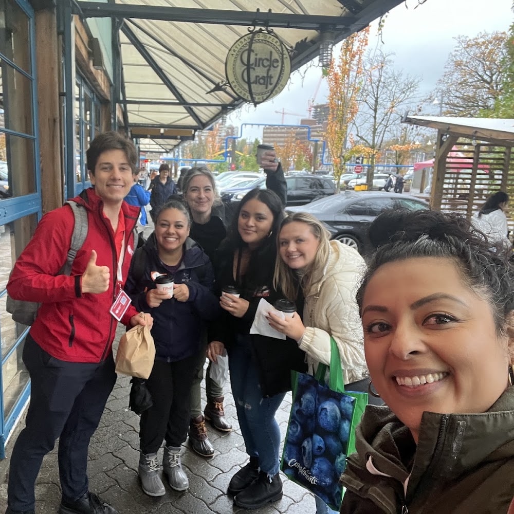 happy team members taking a selfie with their tour guide during their team building activity with Vancouver Foodie Tours