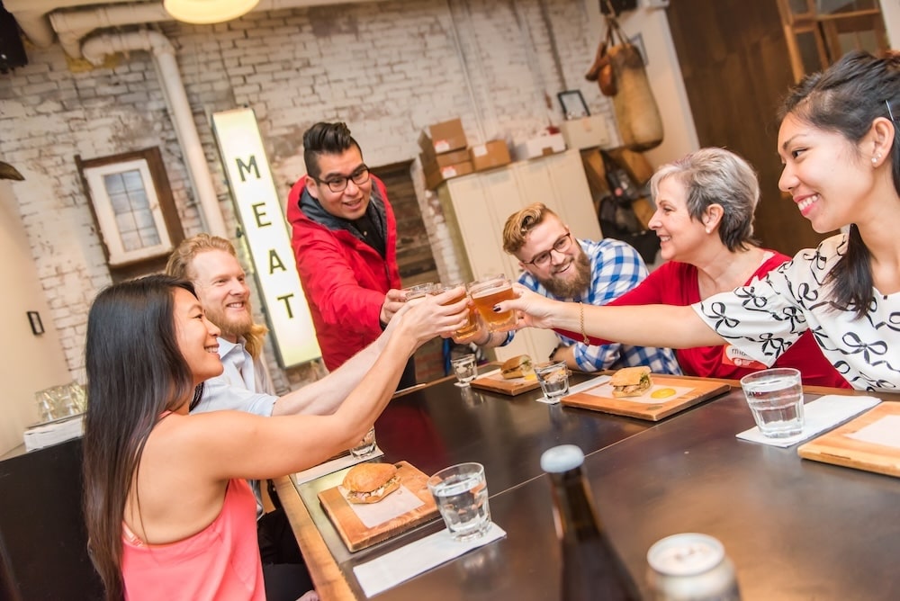 a team of coworkers raising their beer glasses after a successful corporate event with Vancouver Foodie Tours