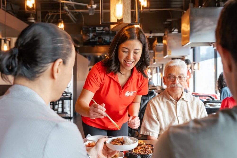 a foodie tour guide serving asian food to her guests of the immersive asian food tour of Vancouver