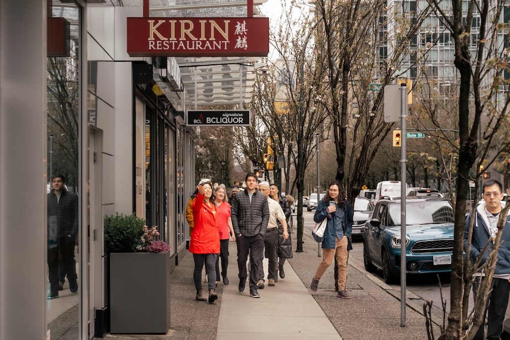 a foodie tour guide leading her group of travelers through the streets of Downtown Vancouver on a foodie adventure filled with authentic Asian cuisine