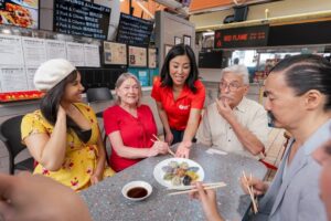 A local tour guide sharing a plate of Asian dumplings with her corporate group of guests on the Authentic Asian Eats tour in Downtown Vancouver