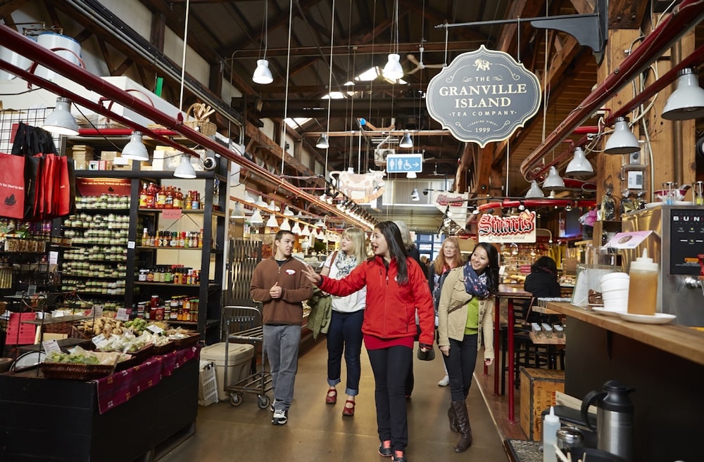 a Vancouver Foodie Tours guide leading a group of visitors through the Public Market on Granville Island