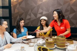 Colleagues sitting at a table in Downtown Vancouver, trying authentic Asian cuisine together as a part of their team-building event