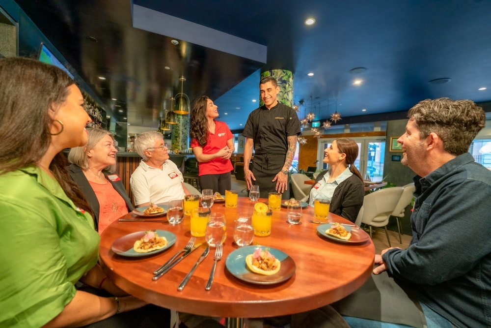 A Vancouver Foodie Tours guide in a red shirt introducing Monarca staff to the guests on a food tour during the Fan Expo event in Vancouver in February 2025