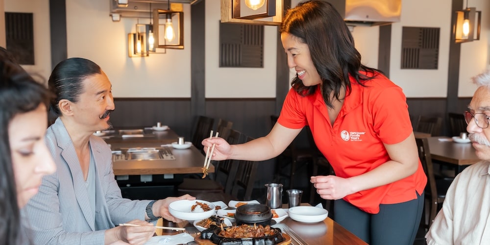 a foodie tour guide serving her guests on an Asian Eats Tour bites of authentic Asian cuisine in Vancouver's Downtown