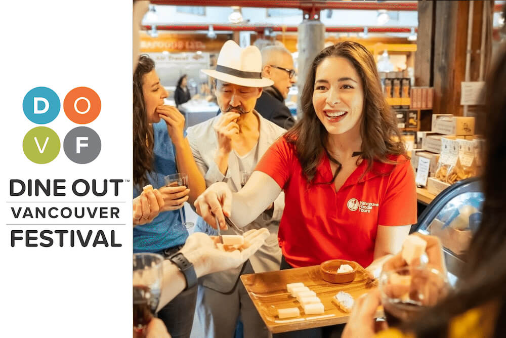 Smiling Vancouver Foodie Tours guide serving tasting bites to guests at Granville Island Market during the Dine Out Vancouver Festival edition of our signature tour.