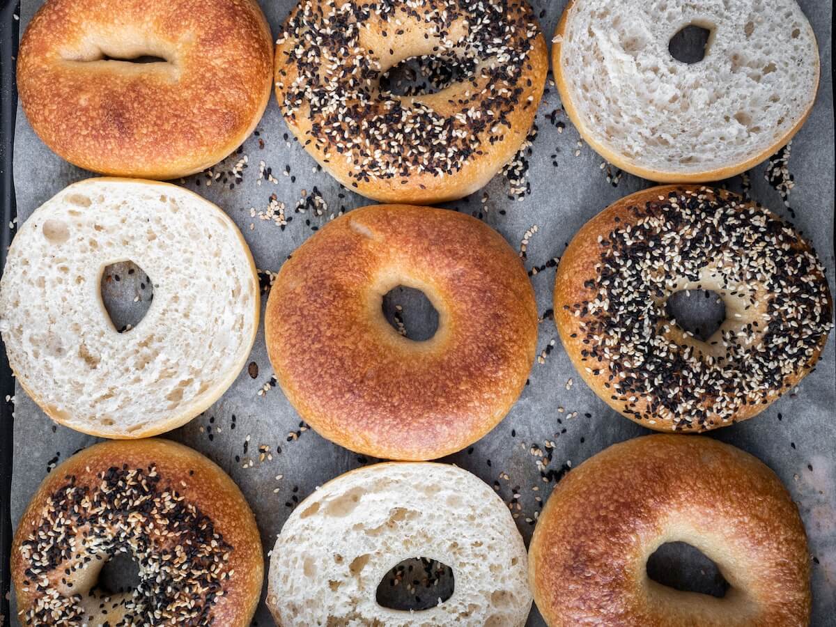 Assorted Montréal-style bagels at Siegel’s Bagels in Granville Island Public Market, including sesame and plain bagels sliced open.