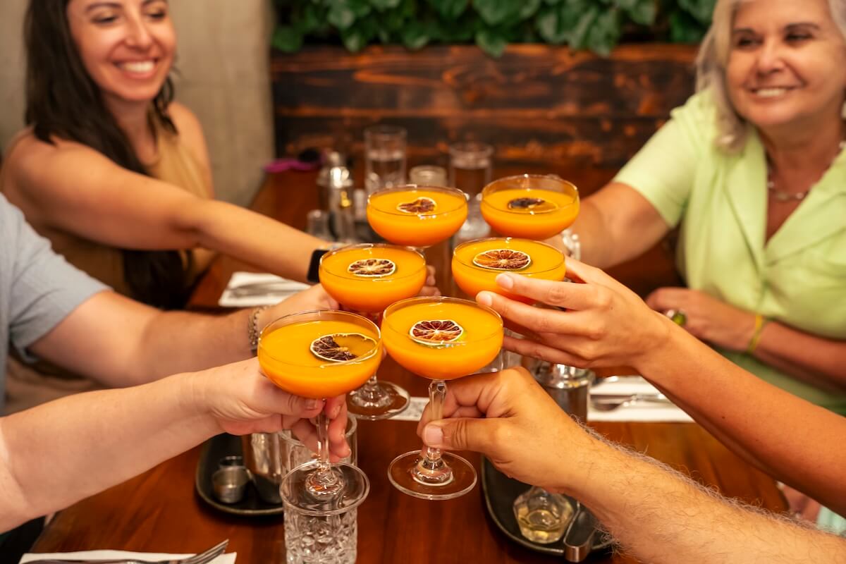 Corporate group toasting cocktails during a Vancouver Foodie Tours team event.