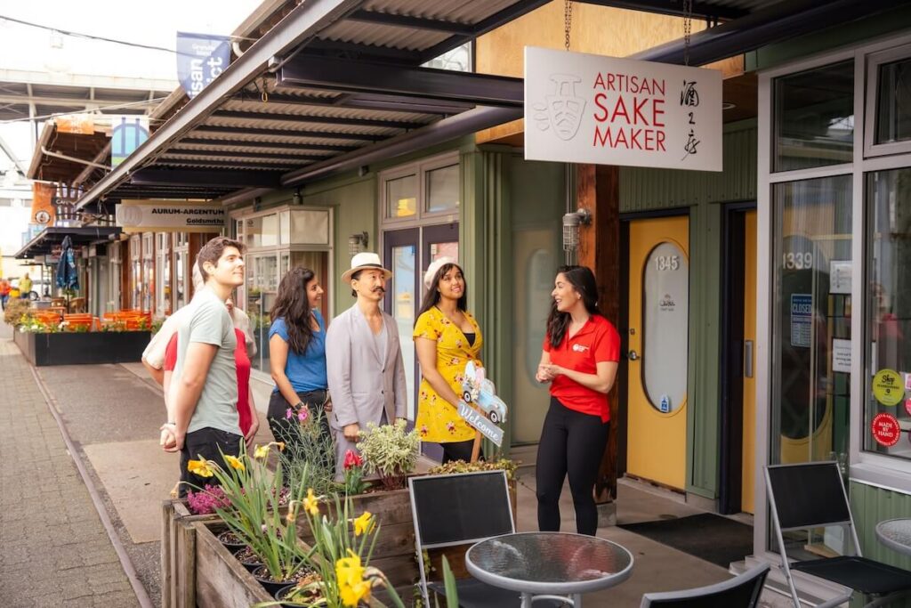 Vancouver Foodie Tours guide speaking with guests outside Artisan Sake Maker on Granville Island.