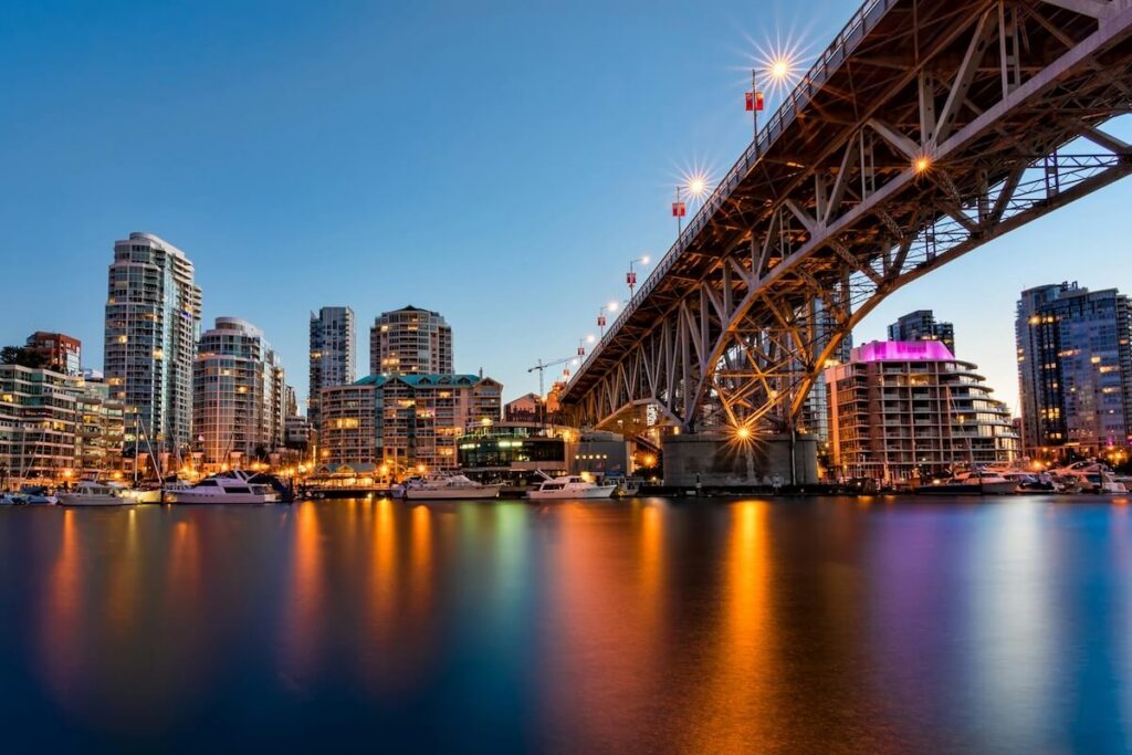 Granville Bridge over False Creek at dusk with Granville Island waterfront lights in Vancouver.