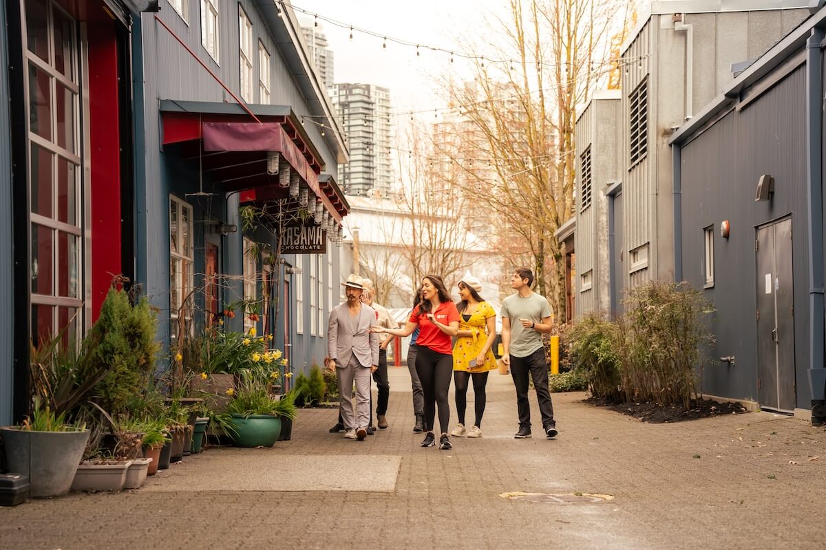 Guide leading a small group down a lane on Granville Island in Vancouver.