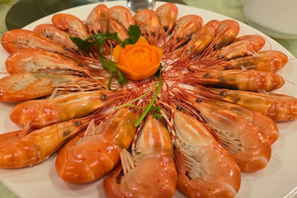 Cooked BC spot prawns served on a white platter with herb garnish
