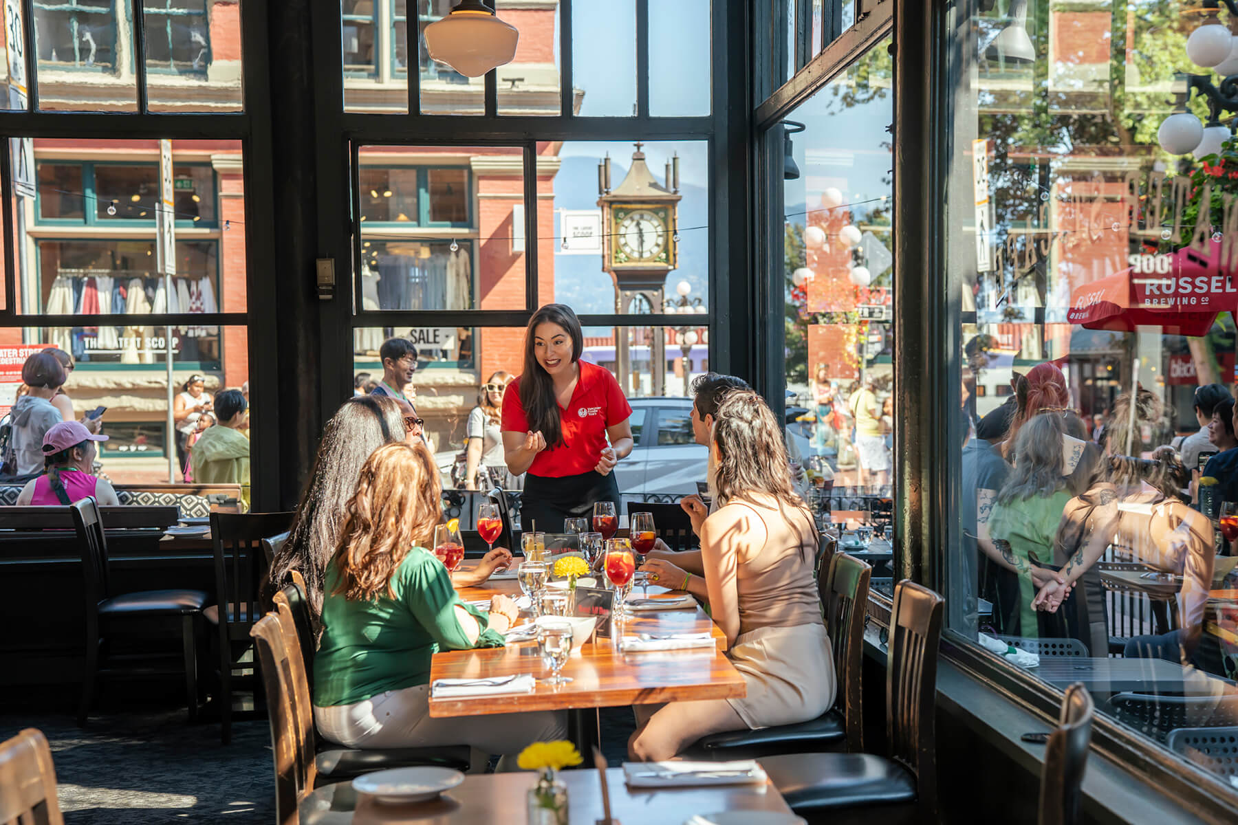 Vancouver Foodie Tours guide speaking to guests inside a Gastown restaurant during the Gastronomic Gastown Tour