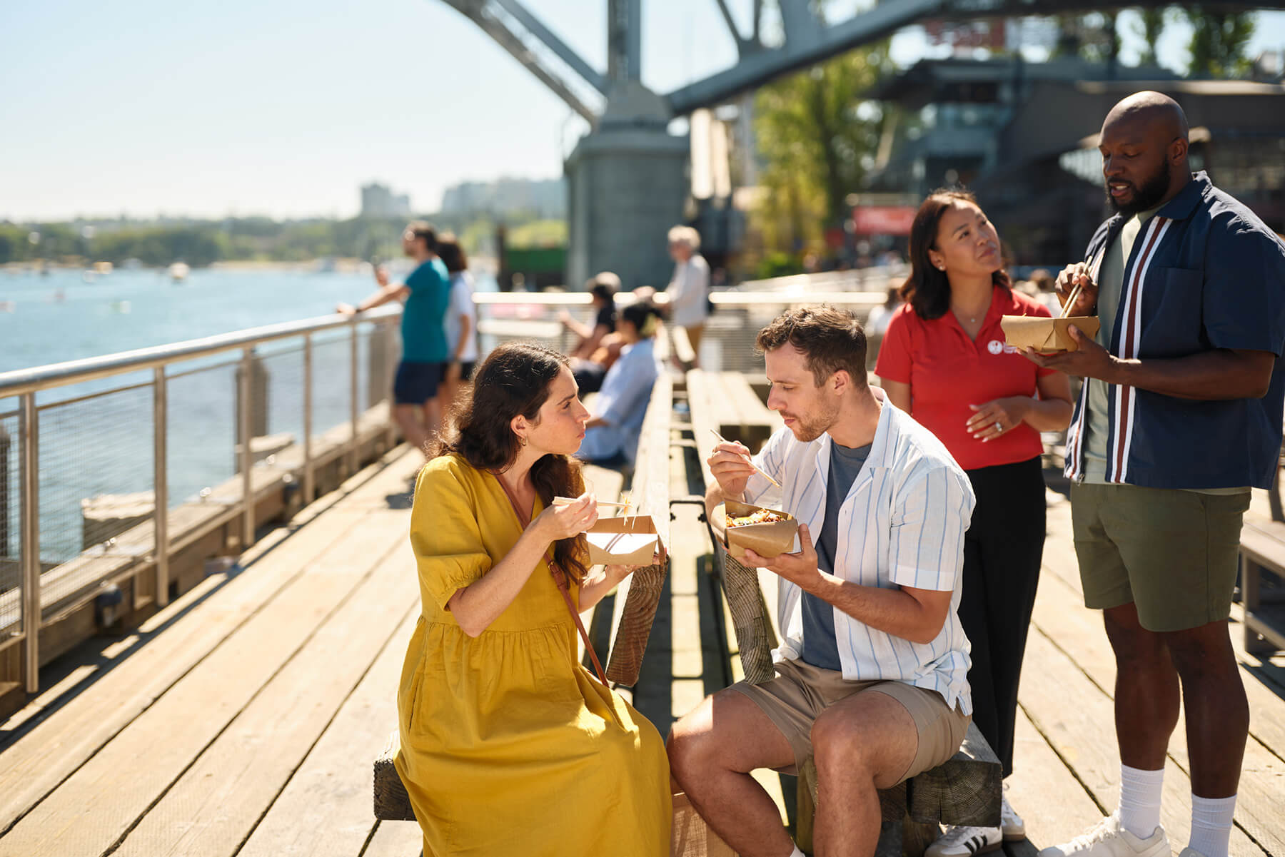 Guests enjoying an outdoor tasting near False Creek during a Granville Island food tour in Vancouver