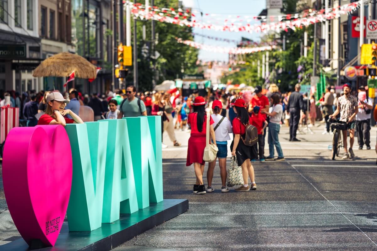 Crowds enjoy a busy Vancouver street festival during the summer peak season