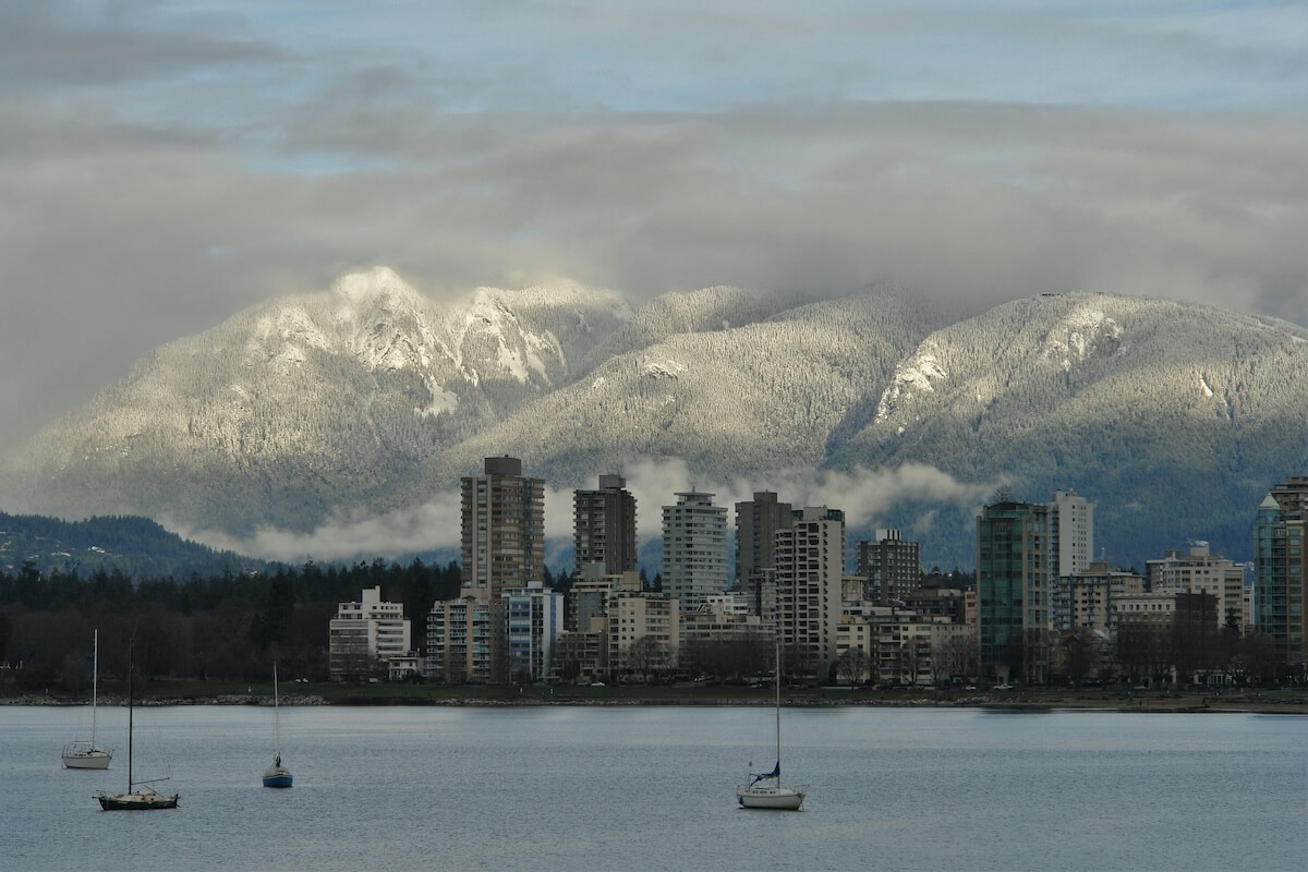 Vancouver skyline and harbor beneath snow-covered North Shore mountains in winter