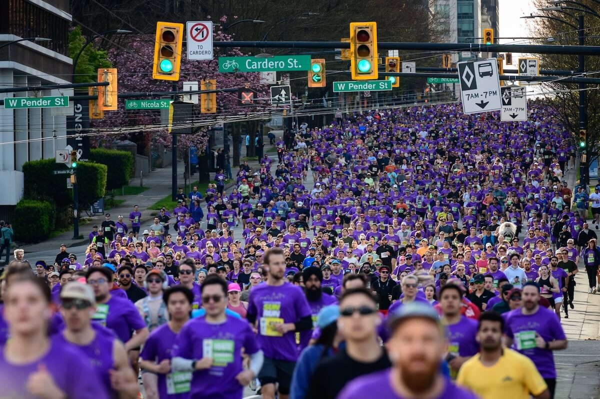 Large crowd of runners filling West Pender Street during the Vancouver Sun Run in downtown Vancouver.