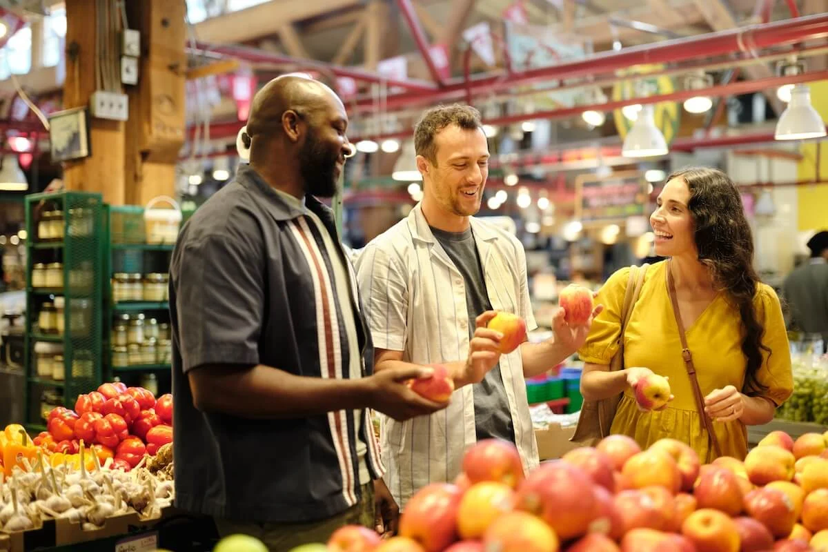 Guests sampling fresh fruit at a produce stall inside Granville Island Public Market in Vancouver