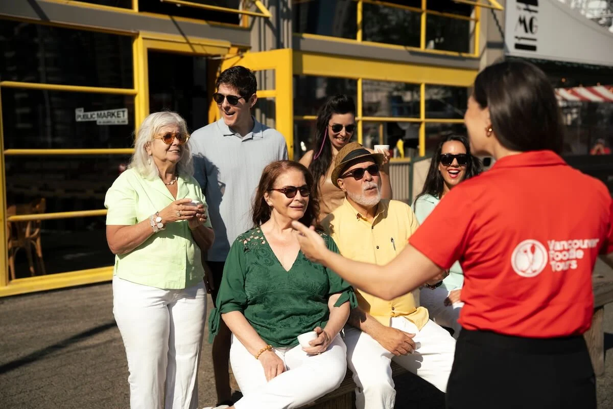 Vancouver Foodie Tours guide talking with a small group of guests on Granville Island